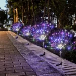 Solarne lampe u obliku drvca sa šarenim svetlima koje osvetljavaju baštu ili dvorište
