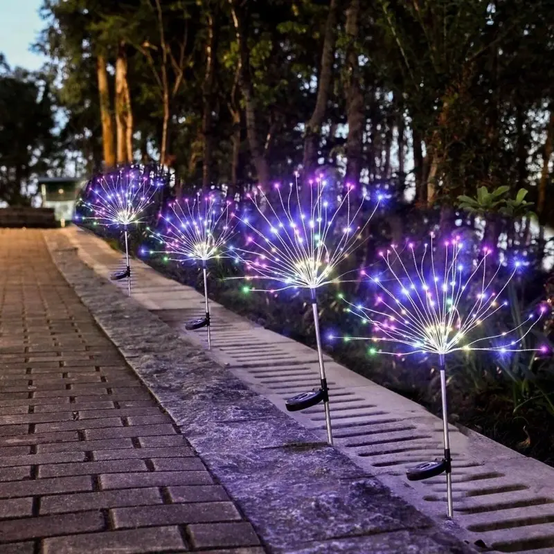 Solarne lampe u obliku drvca sa šarenim svetlima koje osvetljavaju baštu ili dvorište